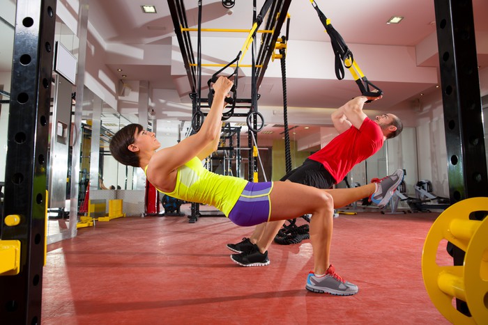 Fitness TRX træning øvelser på gym kvinde og mand