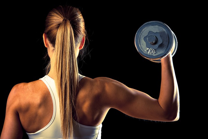 Fitness girl - attractive young woman working out with dumbbells Poster