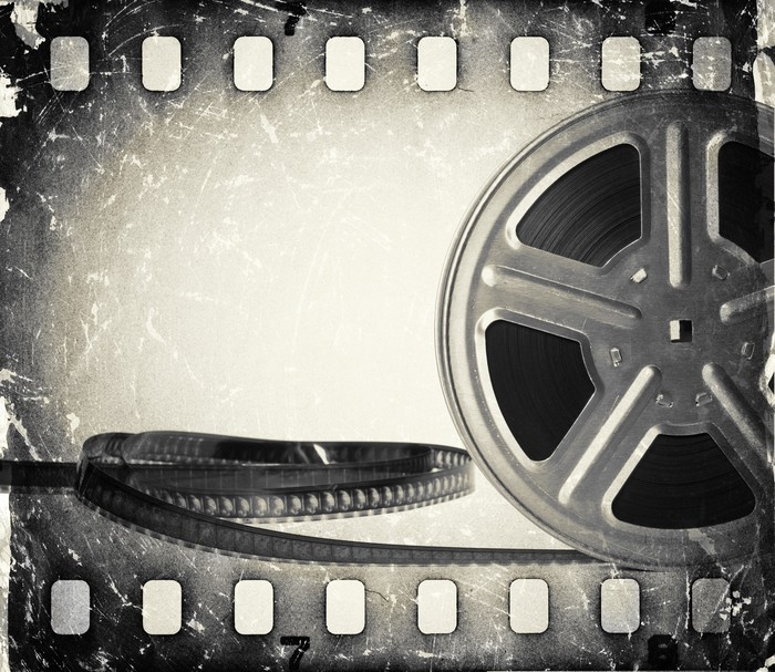 Grunge Old Motion Picture Film Reel With Film Strip Wall